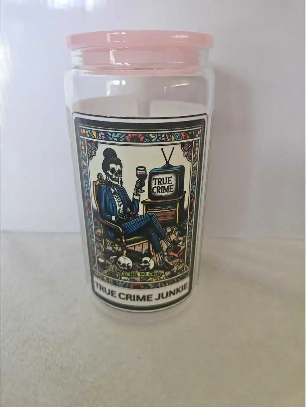 16 oz glass cup with acrylic Lid. Featuring skeletons and flowers.